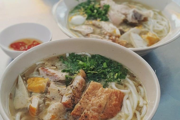 Bát bún chả Hà Nội thơm ngon với thịt nướng, rau thơm và nước dùng đậm đà, kèm bát nước chấm chua cay.