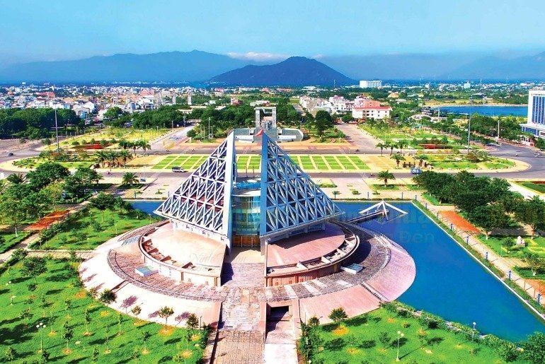 Kiến trúc nhà thờ mái chóp nổi bật tại thành phố hiện đại với núi non xanh biếc ở hậu cảnh, hòa quyện thiên nhiên.