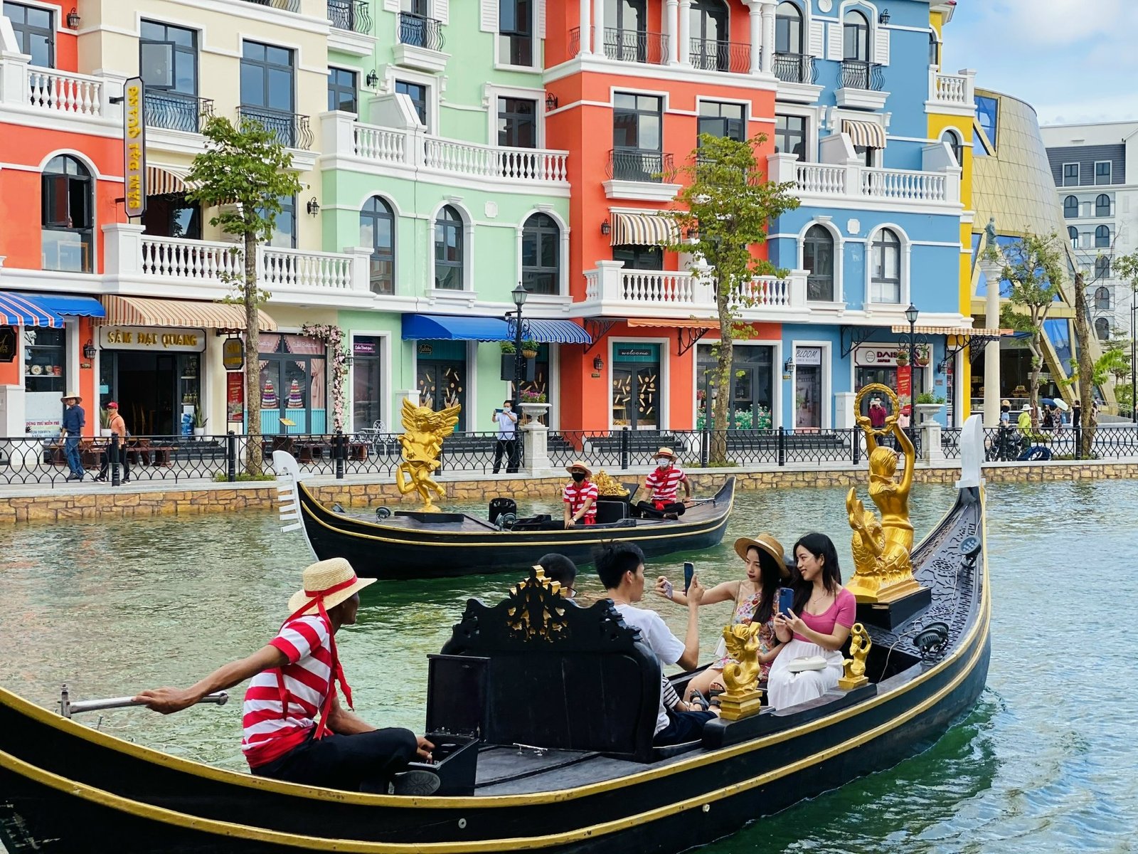 Du khách ngồi trên thuyền gondola dạo quanh dòng kênh bên cạnh các tòa nhà rực rỡ sắc màu ở Venesia Việt Nam.