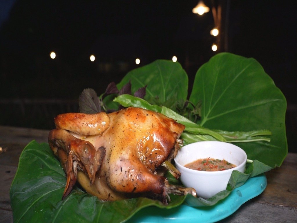 Gà nướng thơm lừng trên lá chuối, đi kèm nước chấm đậm đà, bày trí đẹp mắt bên đĩa, tạo cảm giác hấp dẫn và ngon miệng.