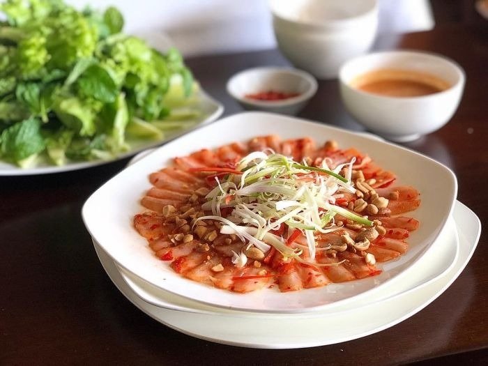 Đĩa gỏi cá trích tươi ngon với rau sống và nước chấm, cách bài trí đẹp mắt trên bàn ăn truyền thống.
