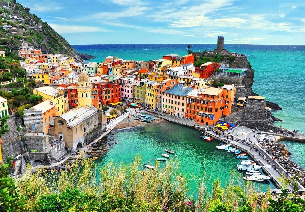 Phong cảnh tuyệt đẹp của Vernazza ở Cinque Terre, Ý, với các tòa nhà nhiều màu sắc, bến cảng và biển xanh.