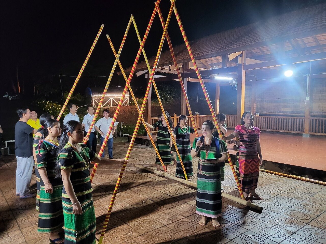 Nhóm phụ nữ trong trang phục truyền thống biểu diễn điệu múa sạp tại một buổi lễ văn hóa dân tộc vào ban đêm.