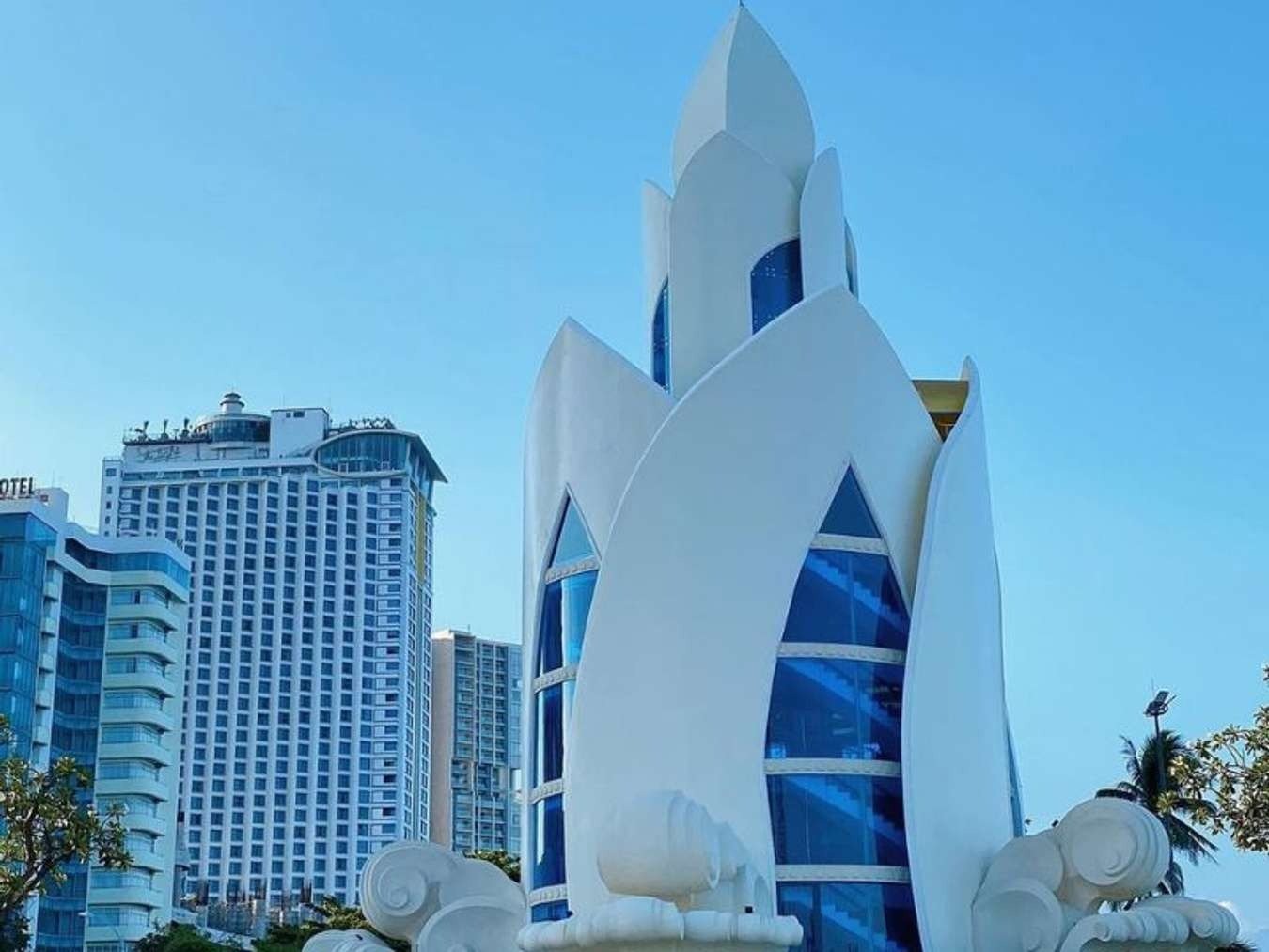 Tháp Trầm Hương, một biểu tượng nổi bật của thành phố biển Nha Trang, đứng giữa các tòa nhà hiện đại và bầu trời xanh.