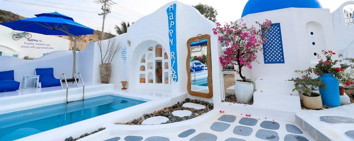 Khu nghỉ dưỡng lấy cảm hứng từ Santorini với hồ bơi xanh ngắt bên những ngôi nhà trắng, cây hoa giấy và không gian tươi mát.