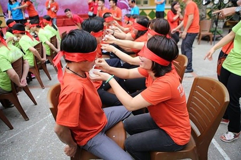Đội ngũ nhân viên tham gia trò chơi bịt mắt cho ăn tại sự kiện teambuilding ngoài trời, xây dựng tinh thần đồng đội.