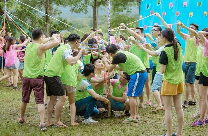 Khám Phá Đắk Lắk: Hành Trình Team Building Đầy Thú Vị Và Khác Biệt 4 Nhóm người tham gia hoạt động xây dựng đội, dùng dây thừng để thực hiện thử thách ngoài trời ở không gian tự nhiên.
