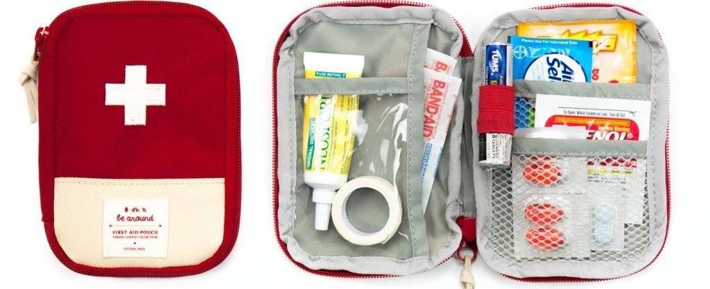 Túi sơ cứu di động nhỏ với biểu tượng chữ thập trắng, chứa đầy đủ dụng cụ băng bó và thuốc thiết yếu cho chuyến đi.