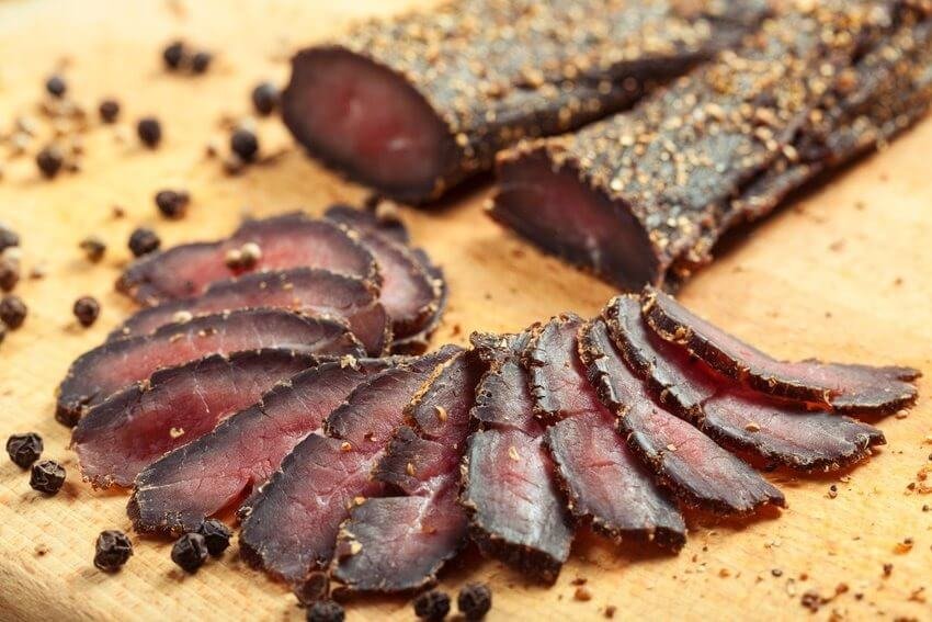 Du lịch Cape Town – Khám phá thành phố đẹp nhất Nam Phi 5 Thịt biltong Nam Phi thái lát trên thớt gỗ, rắc tiêu đen, tạo hương vị truyền thống đậm đà, hấp dẫn.