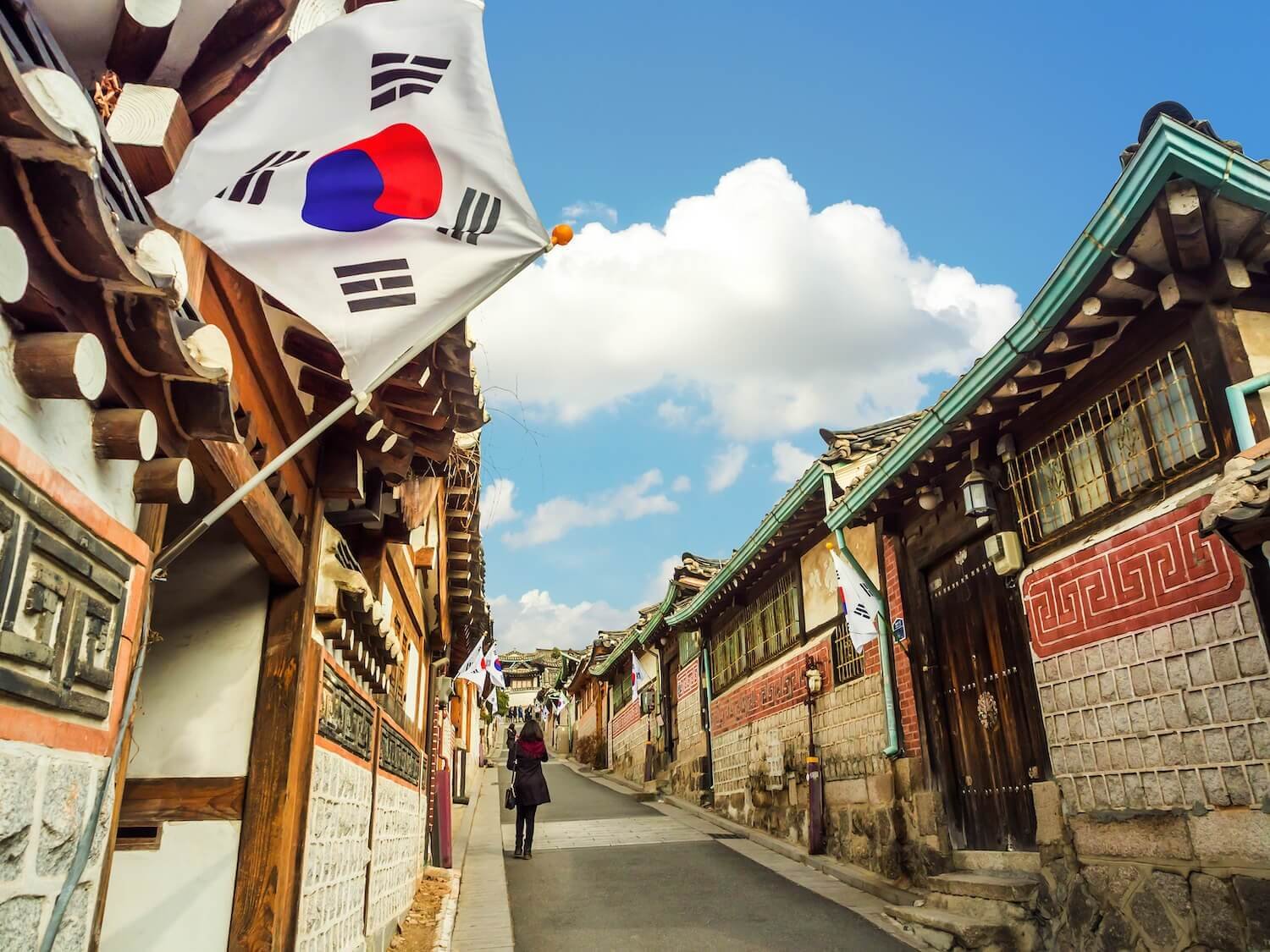 Con phố truyền thống Bukchon Hanok làng ở Seoul với cờ Hàn Quốc tung bay trong gió dưới bầu trời xanh.