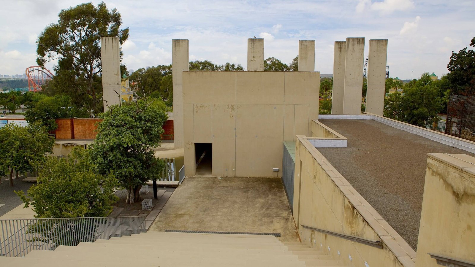 Kinh Nghiệm Du lịch Johannesburg: Thành Phố Bậc Nhất Của Nam Phi 5 Khu vực ngoài trời với kiến trúc hiện đại, bao quanh bởi cây xanh và cột bê tông, nền trời xanh.