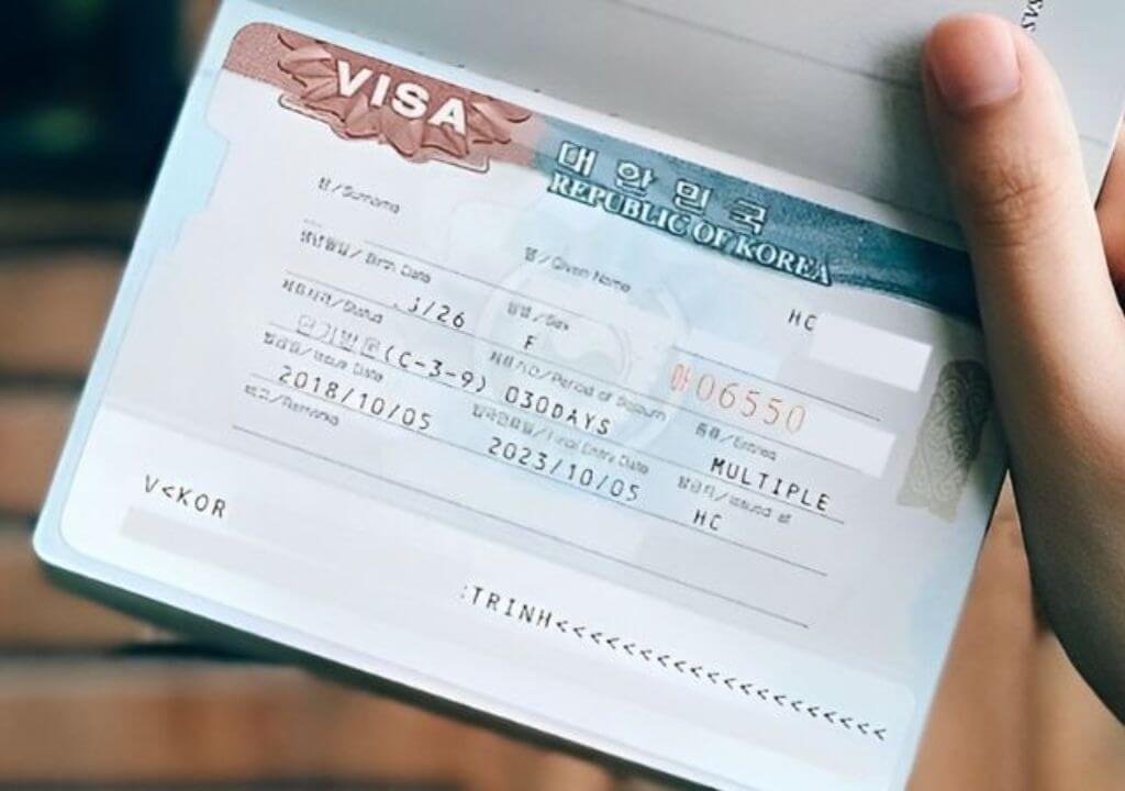 Hộ chiếu và thị thực Hàn Quốc được cầm trên tay, chi tiết visa rõ ràng, phù hợp cho du lịch và nhập cảnh.