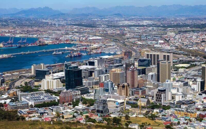 Toàn cảnh thành phố Cape Town, Nam Phi với bến cảng và tòa nhà chọc trời trải dài dưới bầu trời trong xanh.