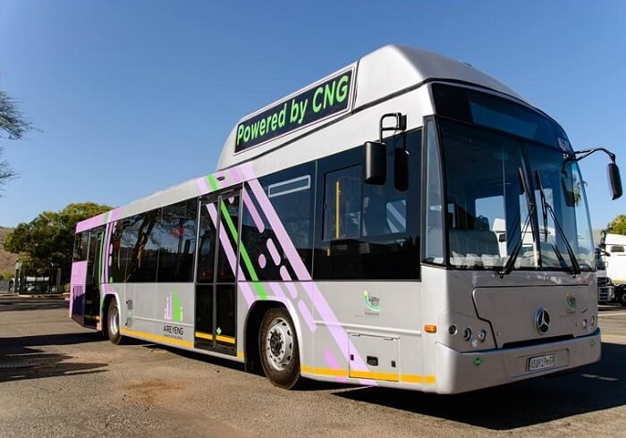 Xe buýt đô thị chạy bằng CNG với thiết kế hiện đại, biển báo Powered by CNG trên đường phố.